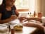 A nail technician filing a client's nails during a manicure at a salon table